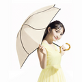 Woman in a yellow dress holding a beige Umbrella Sun_Rain_Lotus on a white background
